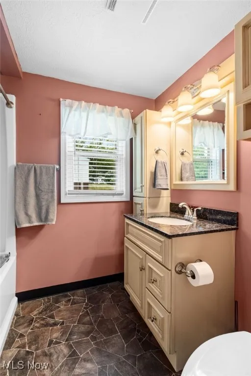 First floor Bathroom with vanity, a bathtub/shower combination, and vinyl floors