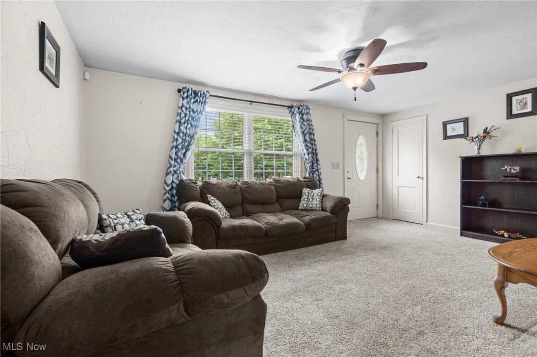 Living room with ceiling fan/light, picture window & coat closet