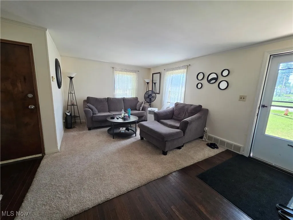 Living area with dark wood-style floors and baseboards
