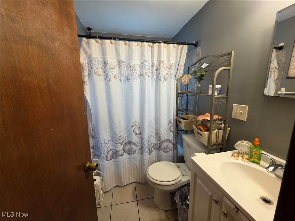 Bathroom with tile patterned flooring, vanity, and a shower with curtain