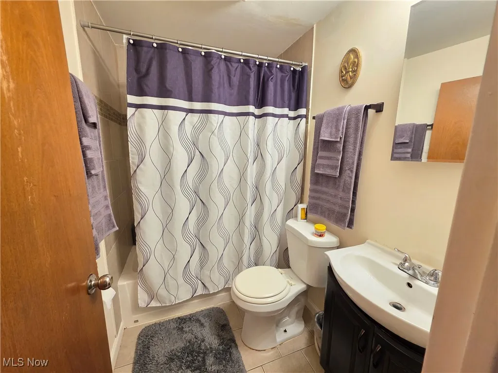 Bathroom featuring tile patterned floors, shower / bath combo, and vanity