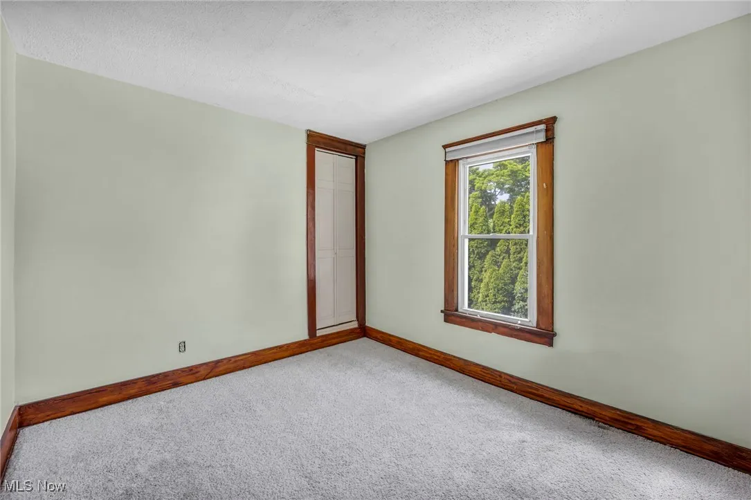 Carpeted empty room featuring a textured ceiling