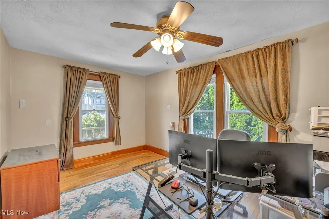 Office area featuring wood finished floors, a ceiling fan, and a textured ceiling