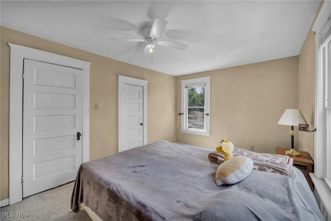 Carpeted bedroom featuring a ceiling fan