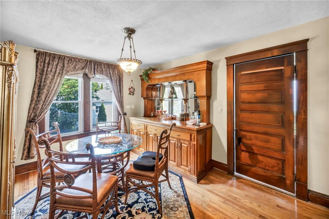 Dining room with light wood-style floors and a textured ceiling