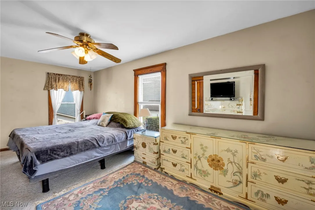Bedroom featuring ceiling fan and carpet