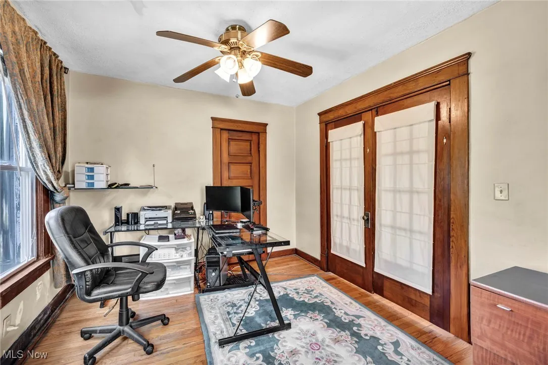 Home office with french doors, a ceiling fan, and wood finished floors