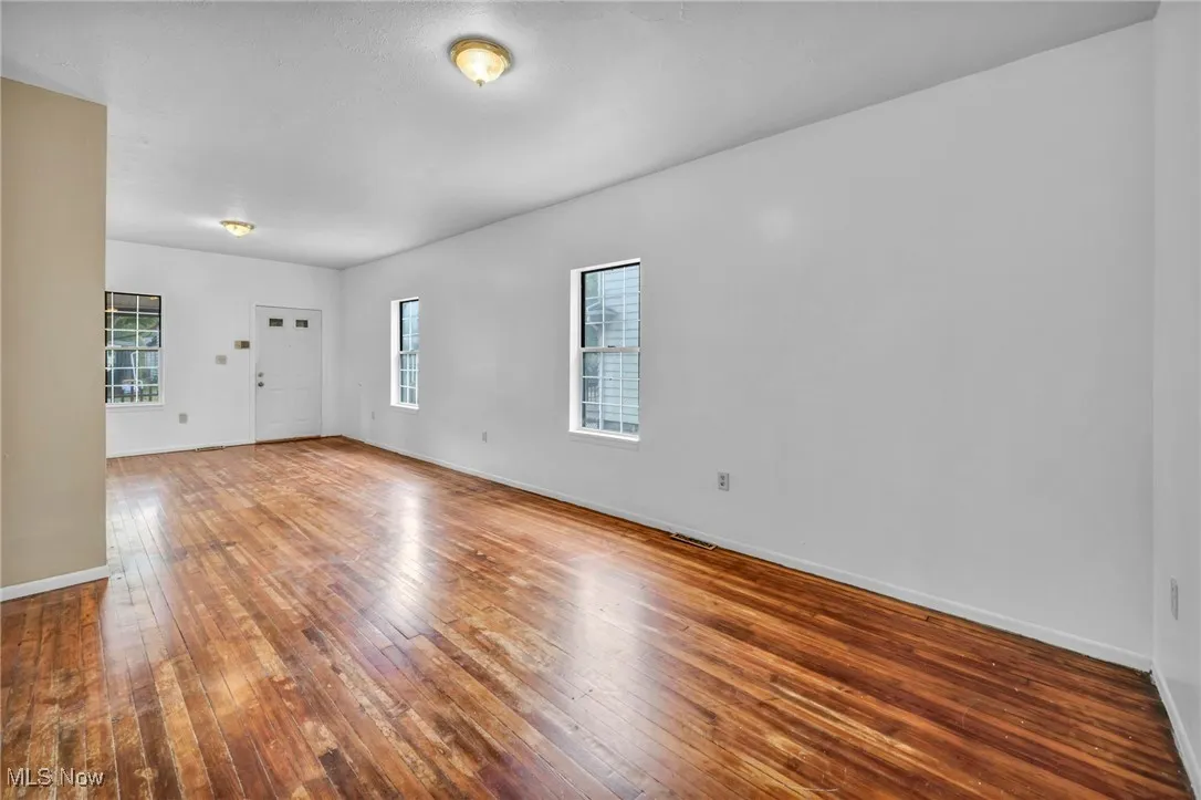 Empty room featuring hardwood / wood-style flooring and baseboards
