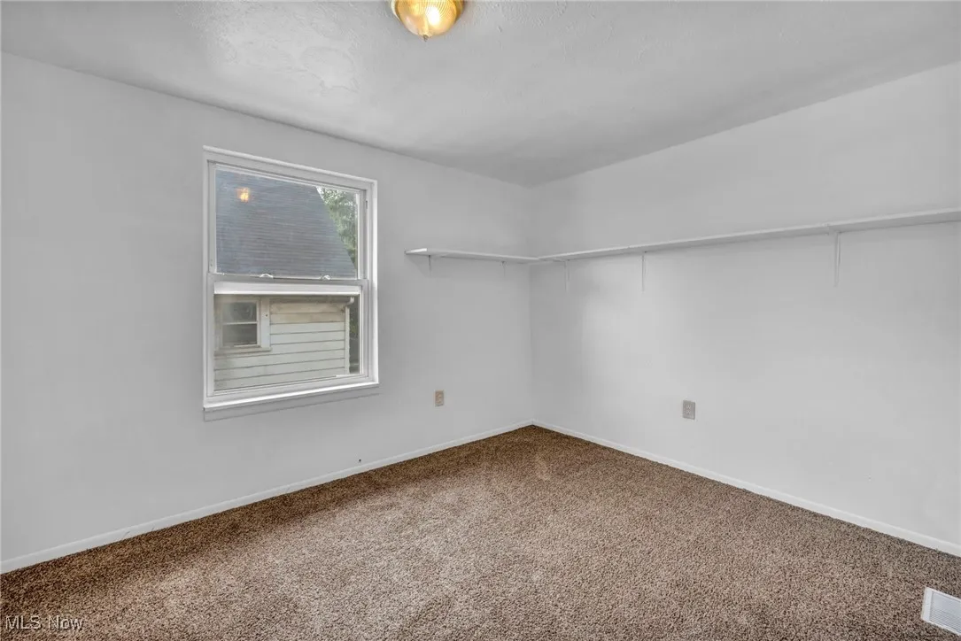 Carpeted spare room with baseboards