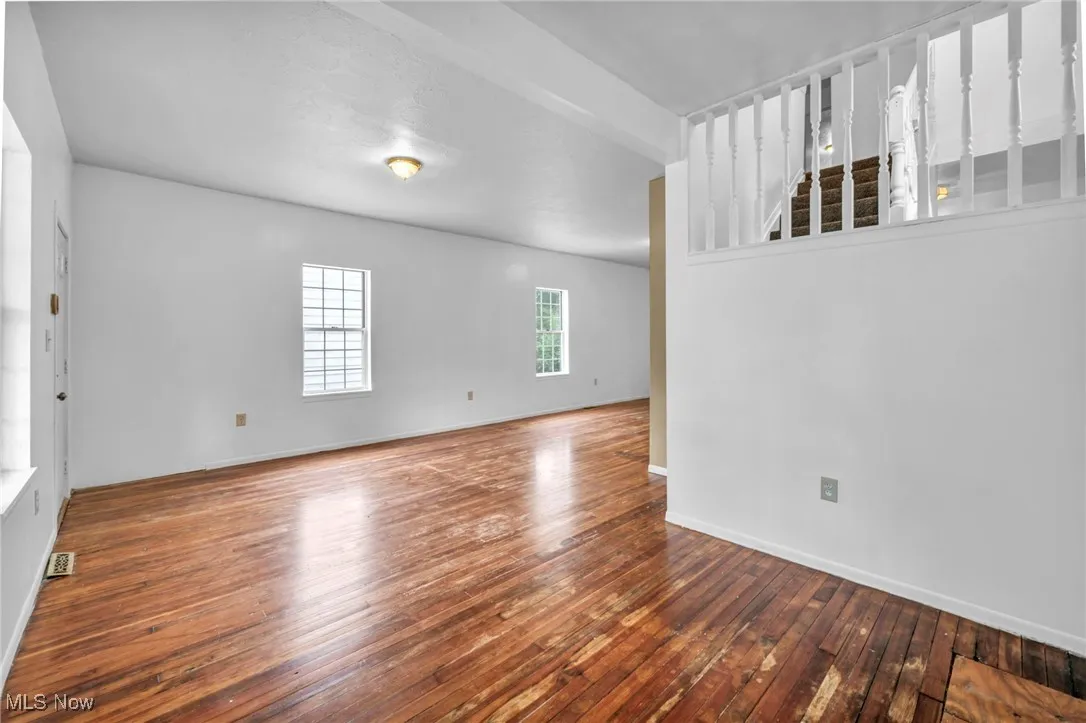 Unfurnished room with wood-type flooring and baseboards
