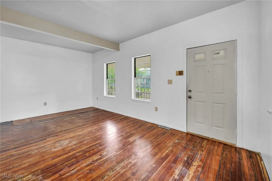 Foyer with hardwood / wood-style floors and beam ceiling