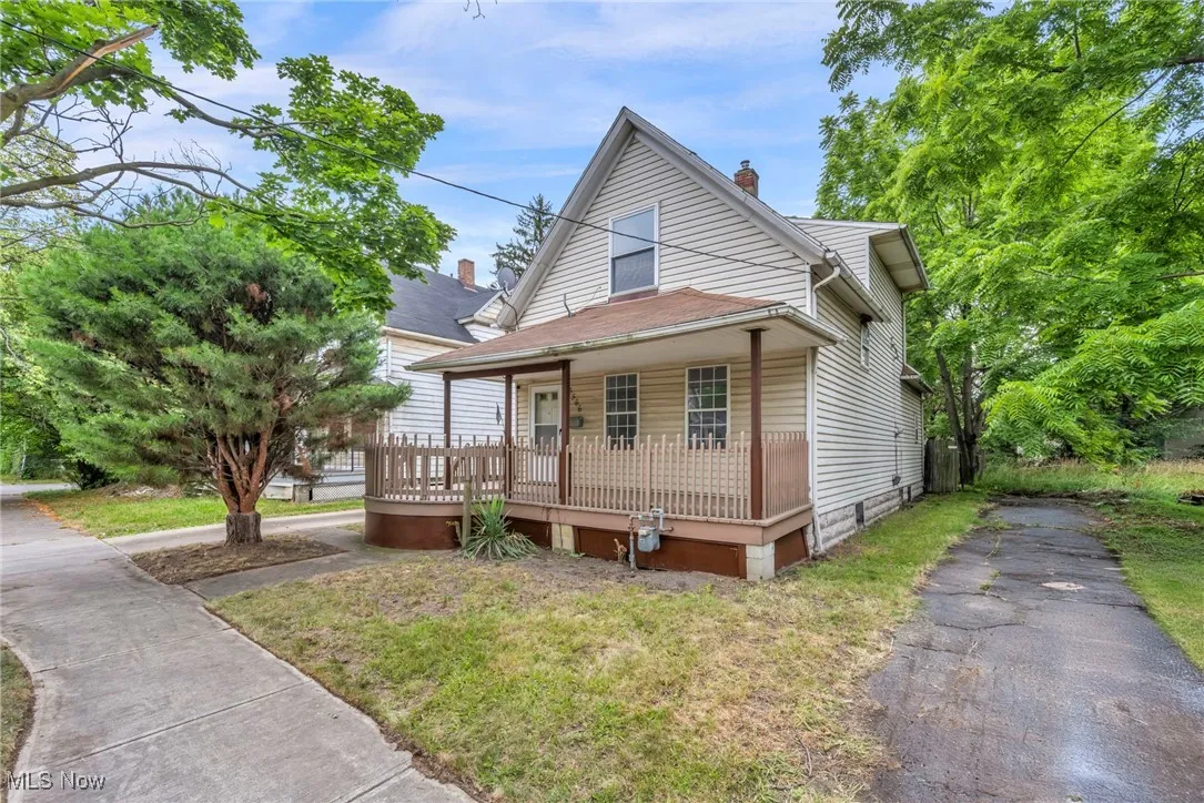 Bungalow featuring a porch, a chimney, and driveway