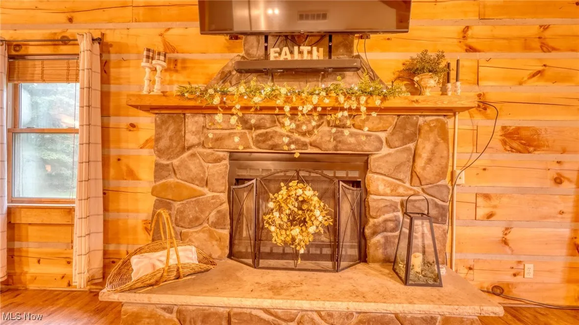 Detailed view of wood walls, wood finished floors, and a fireplace