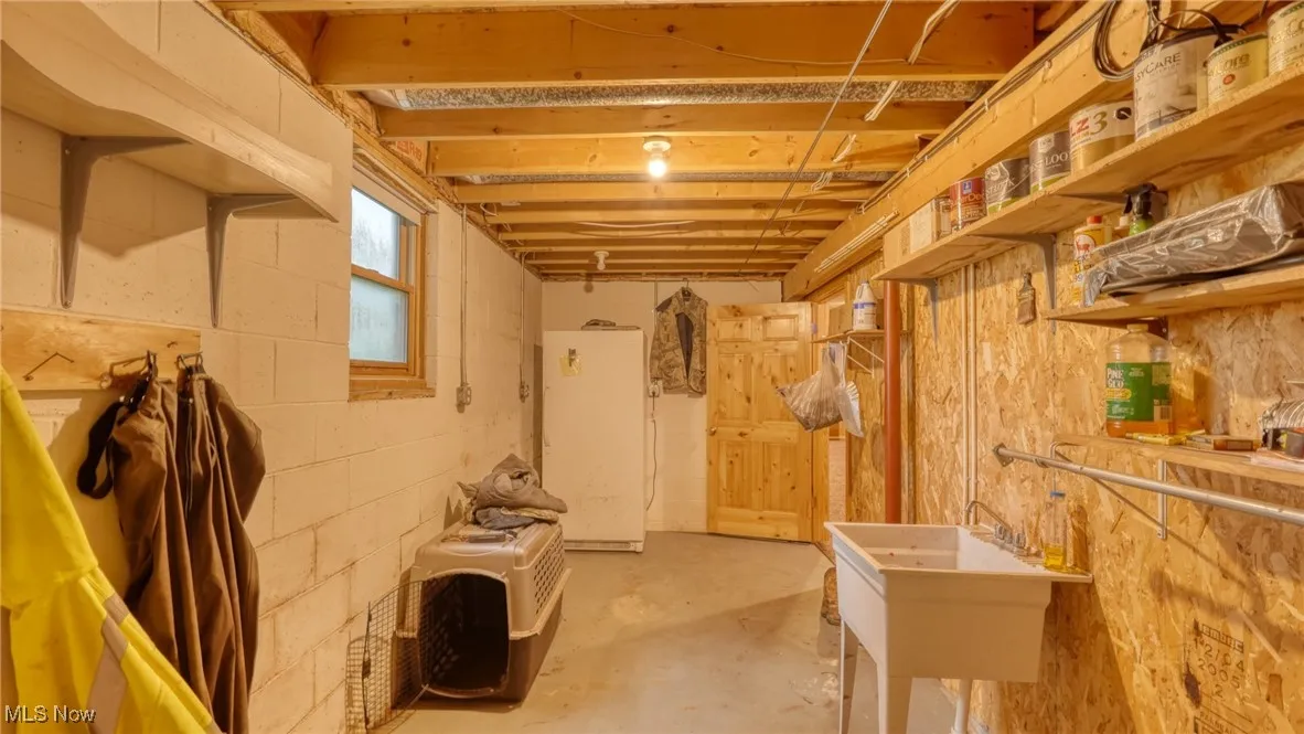 Basement featuring white refrigerator and a sink