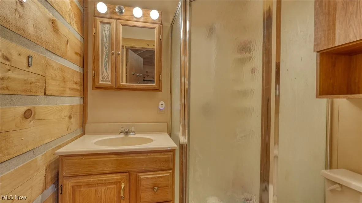 Full bath featuring vanity and a shower stall