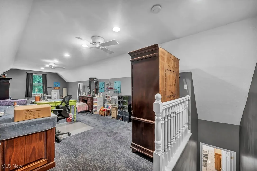 Office space featuring vaulted ceiling, a ceiling fan, carpet floors, and recessed lighting