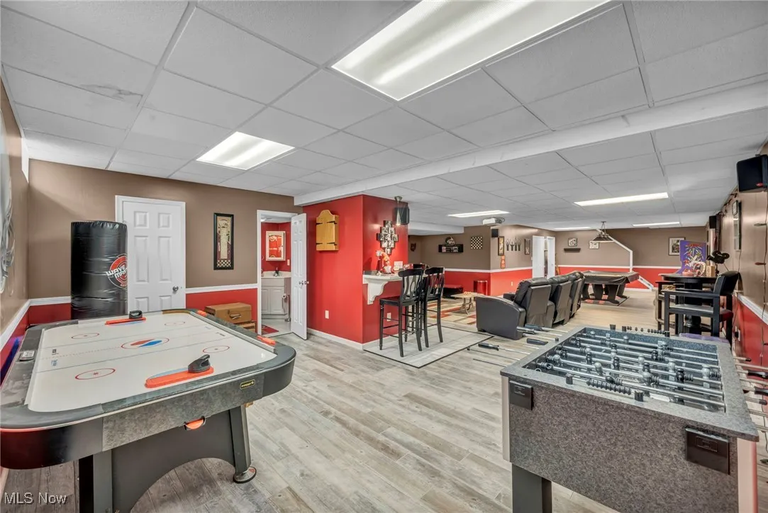 Playroom with a paneled ceiling and wood finished floors