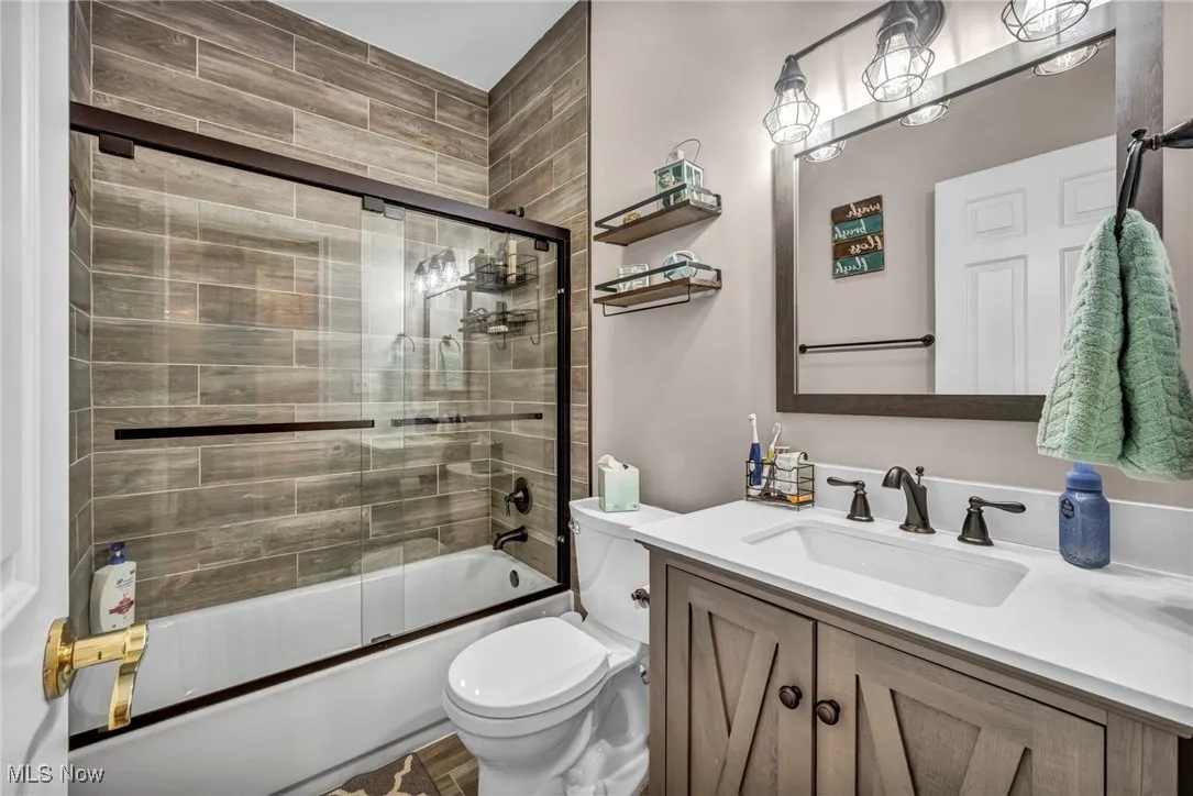 Full bathroom with vanity and shower / bath combination with glass door
