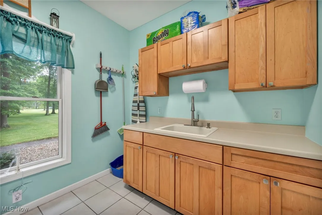 Kitchen with light countertops and light tile patterned flooring