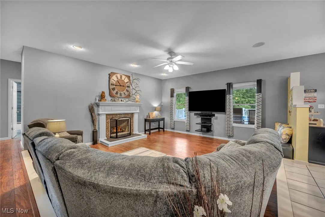Living area featuring ceiling fan, wood finished floors, a fireplace, and recessed lighting