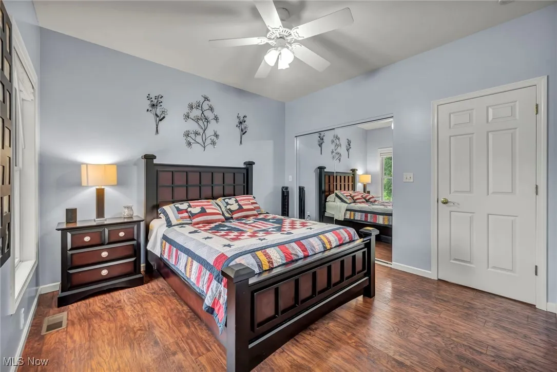 Bedroom with wood finished floors, a closet, and ceiling fan