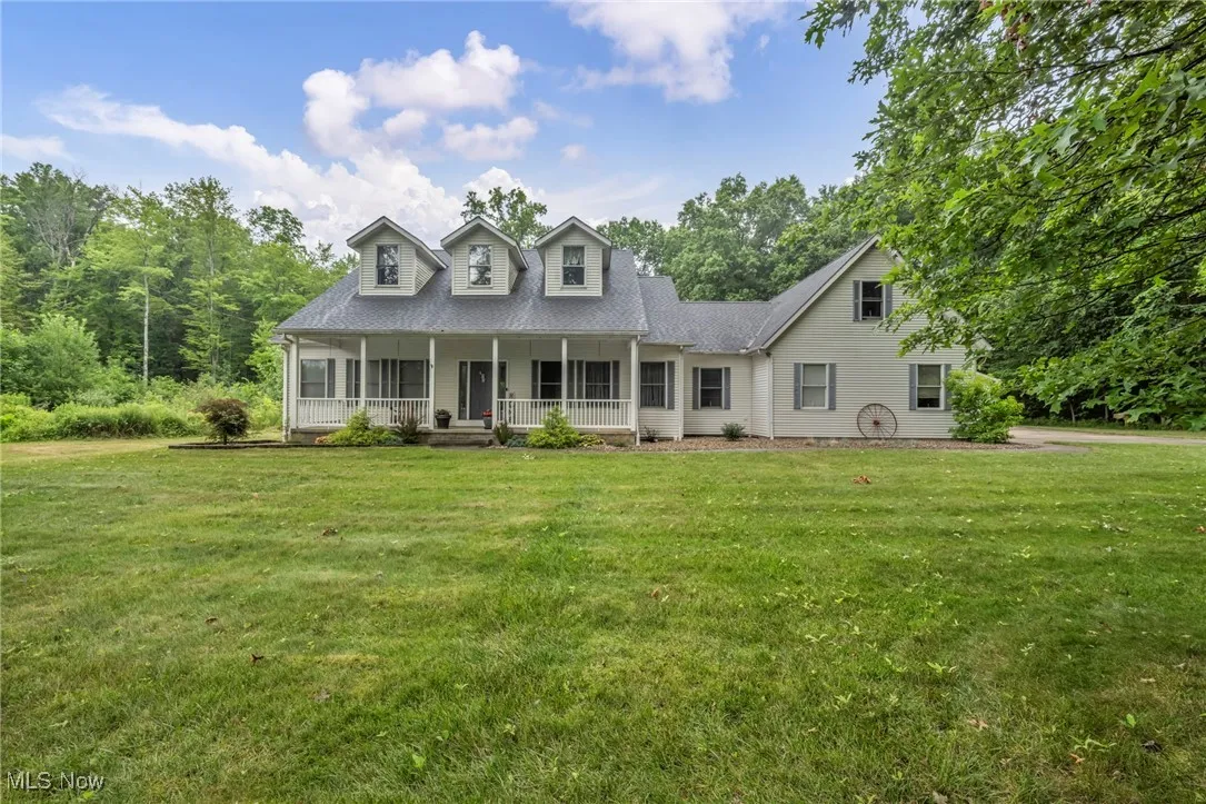Cape cod home with covered porch and a front yard