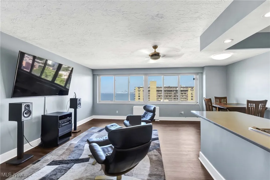 Living room featuring plenty of natural light, dark wood finished floors, a ceiling fan, and recessed lighting