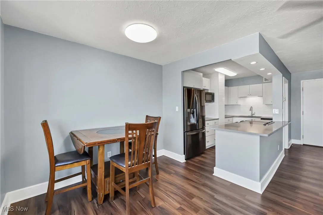 Dining room with dark wood-style flooring and recessed lighting