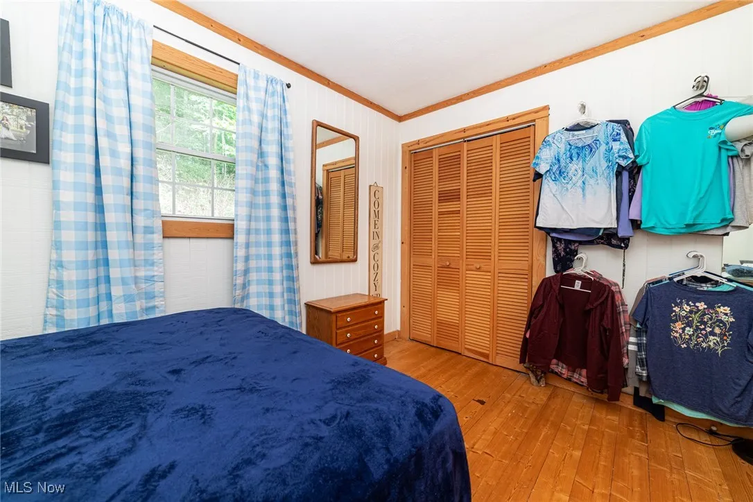 Bedroom featuring hardwood / wood-style flooring and ornamental molding