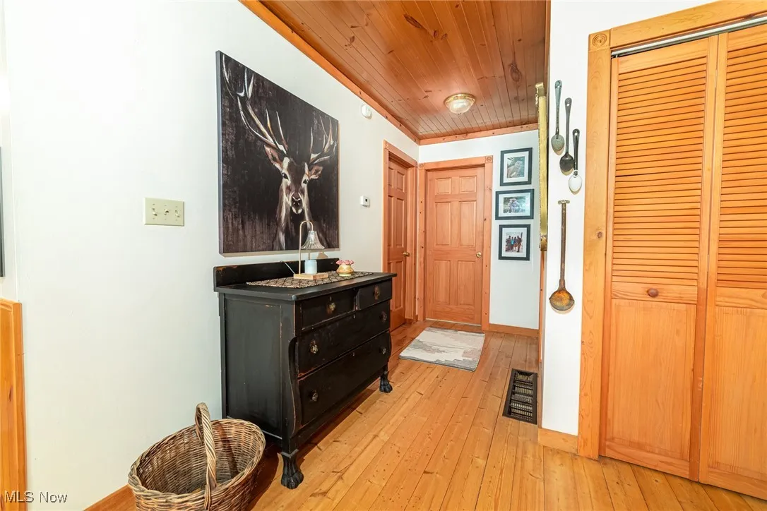Hall featuring light wood-style flooring and wood ceiling