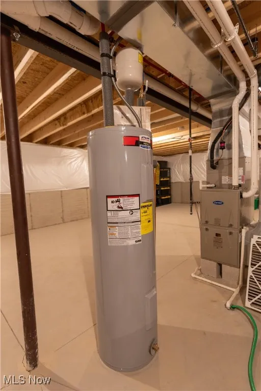 Utility room featuring water heater and heating unit