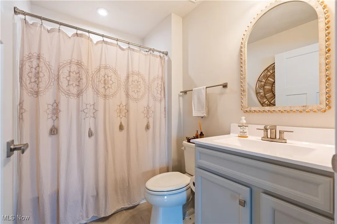 Bathroom featuring vanity, curtained shower, and recessed lighting