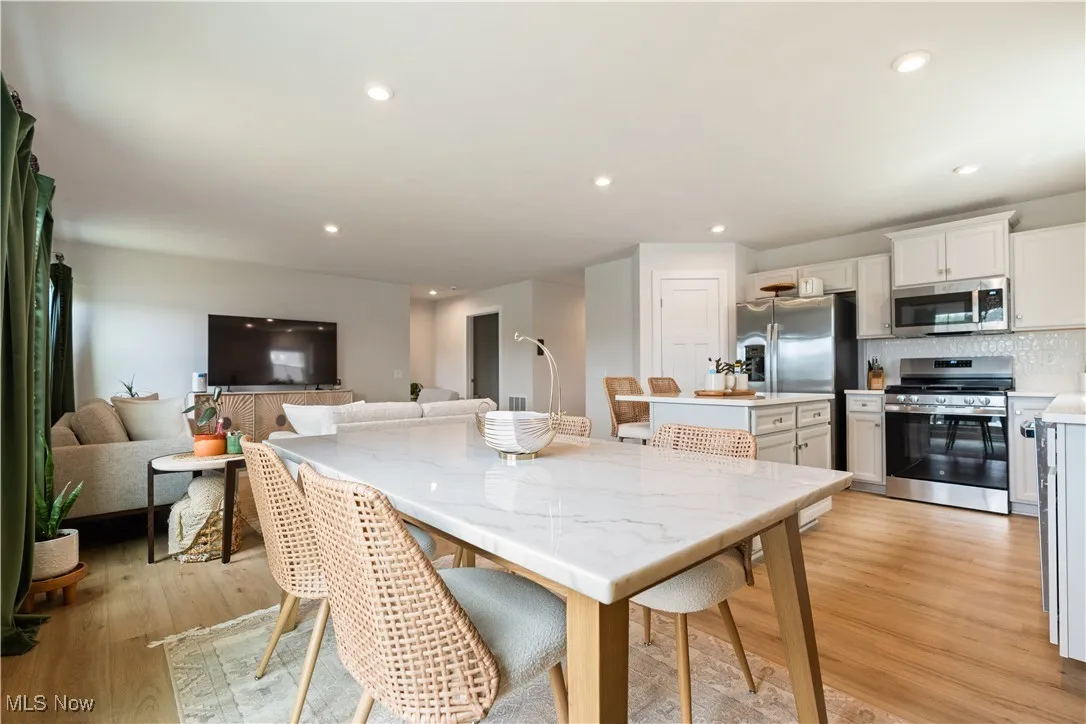 Dining area featuring light wood finished floors and recessed lighting