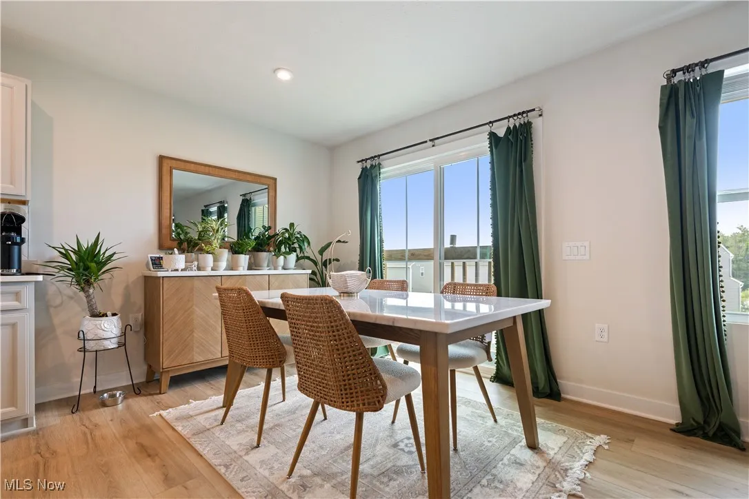 Dining room with light wood-type flooring and recessed lighting