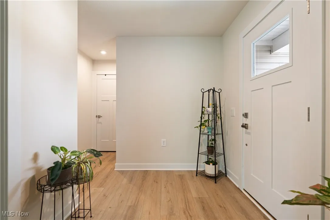 Foyer entrance with light wood finished floors and recessed lighting