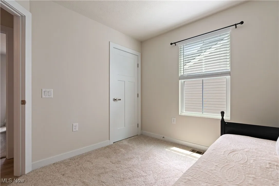 Bedroom featuring carpet and baseboards