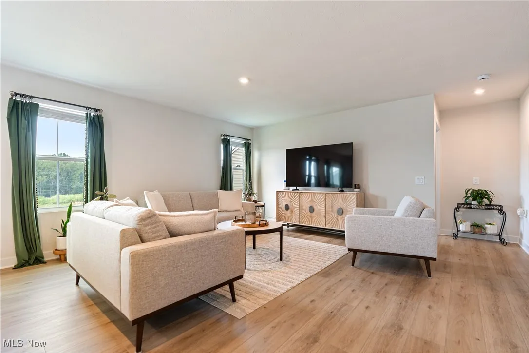 Living area featuring healthy amount of natural light, light wood-style floors, and recessed lighting
