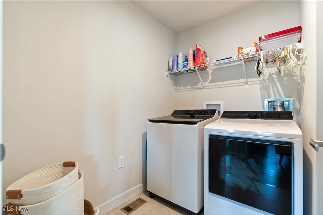 Washroom with separate washer and dryer and baseboards