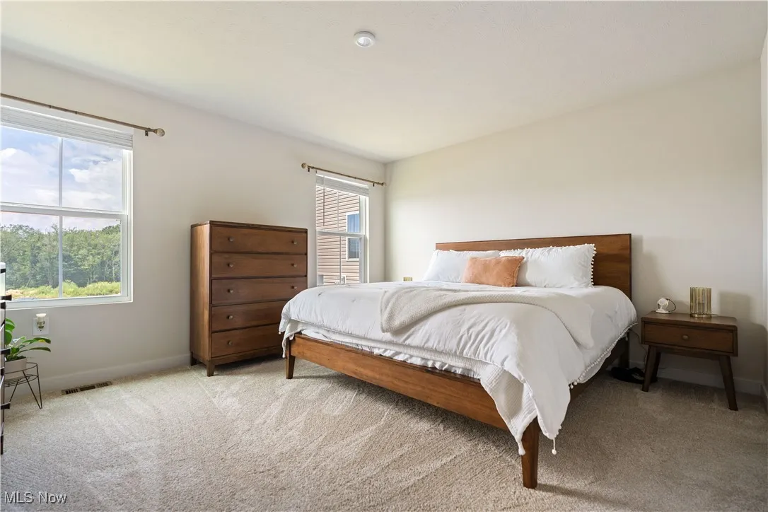 Bedroom featuring light colored carpet and baseboards