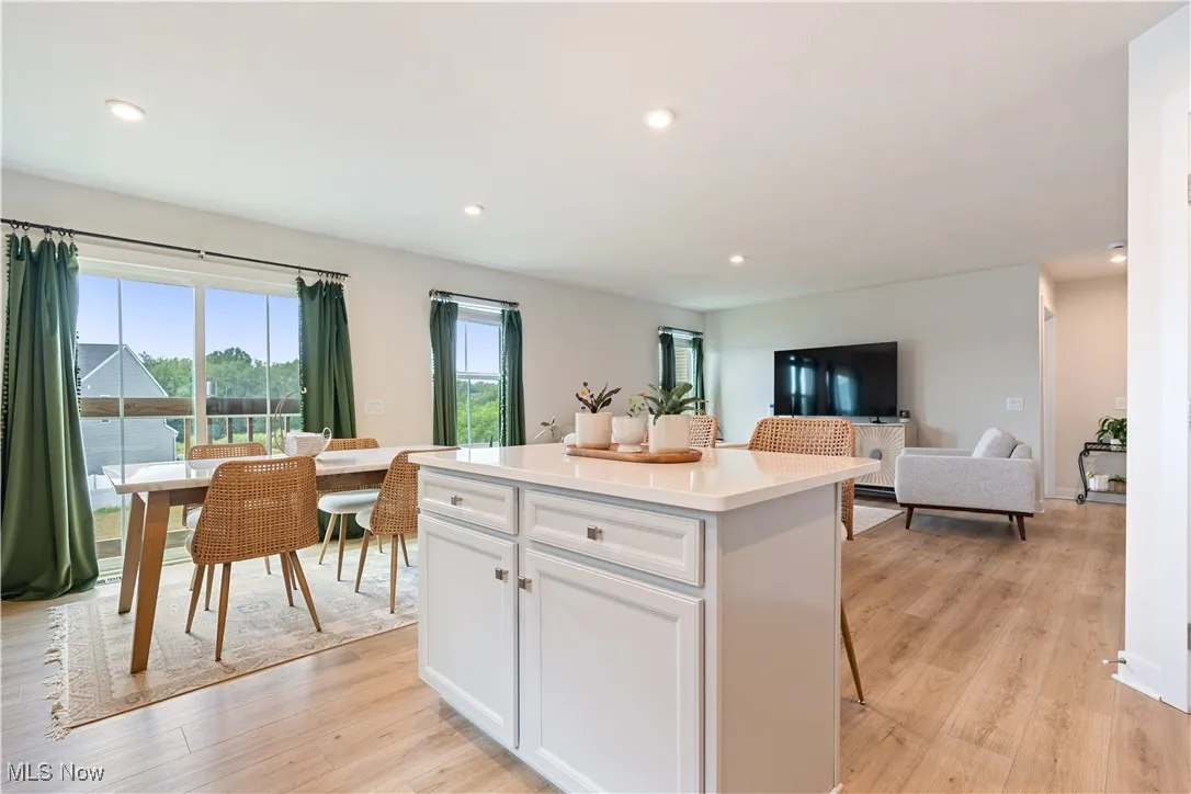 Kitchen with white cabinetry, a center island, light wood-style flooring, light countertops, and recessed lighting