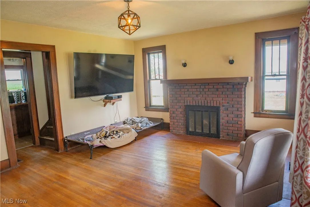 Living area featuring a fireplace, wood finished floors, and plenty of natural light