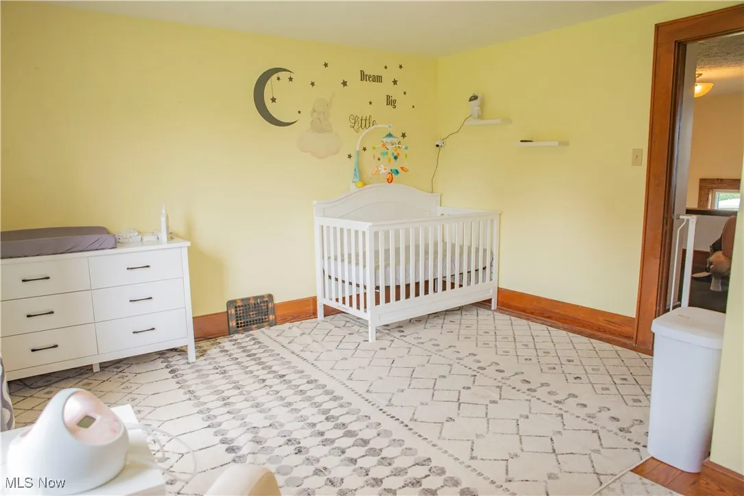 Bedroom featuring a crib and baseboards