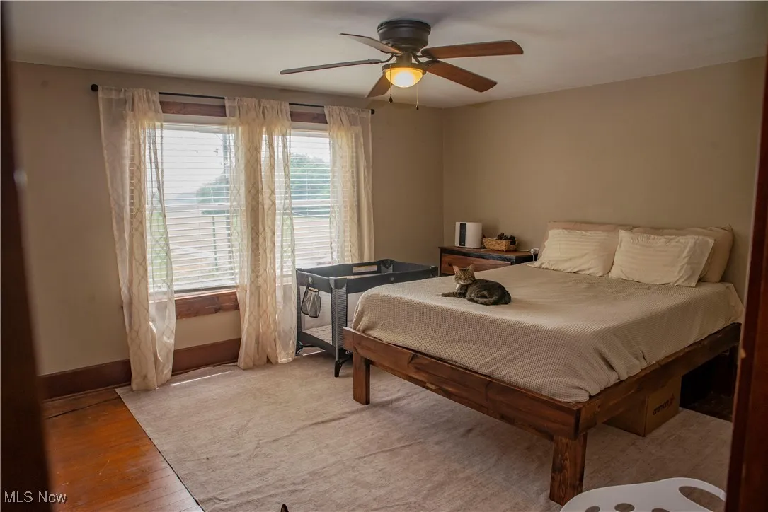 Bedroom with a ceiling fan and light wood-style flooring