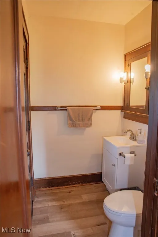 Half bathroom with vanity and wood finished floors