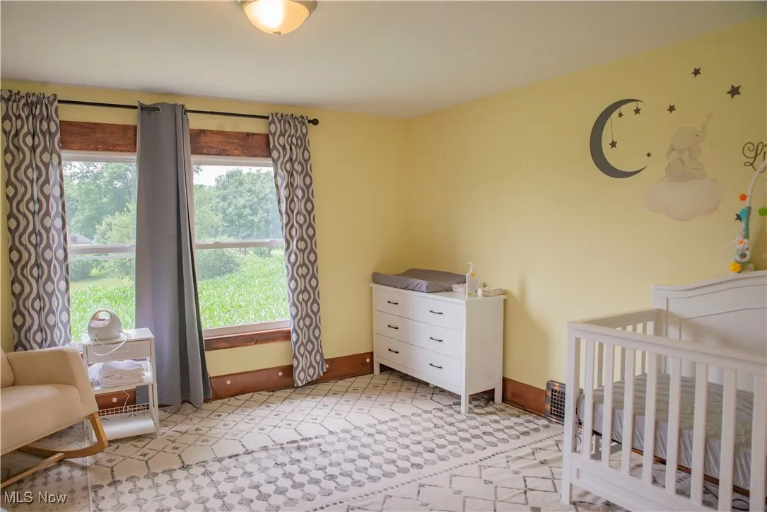 Bedroom with a crib and baseboards