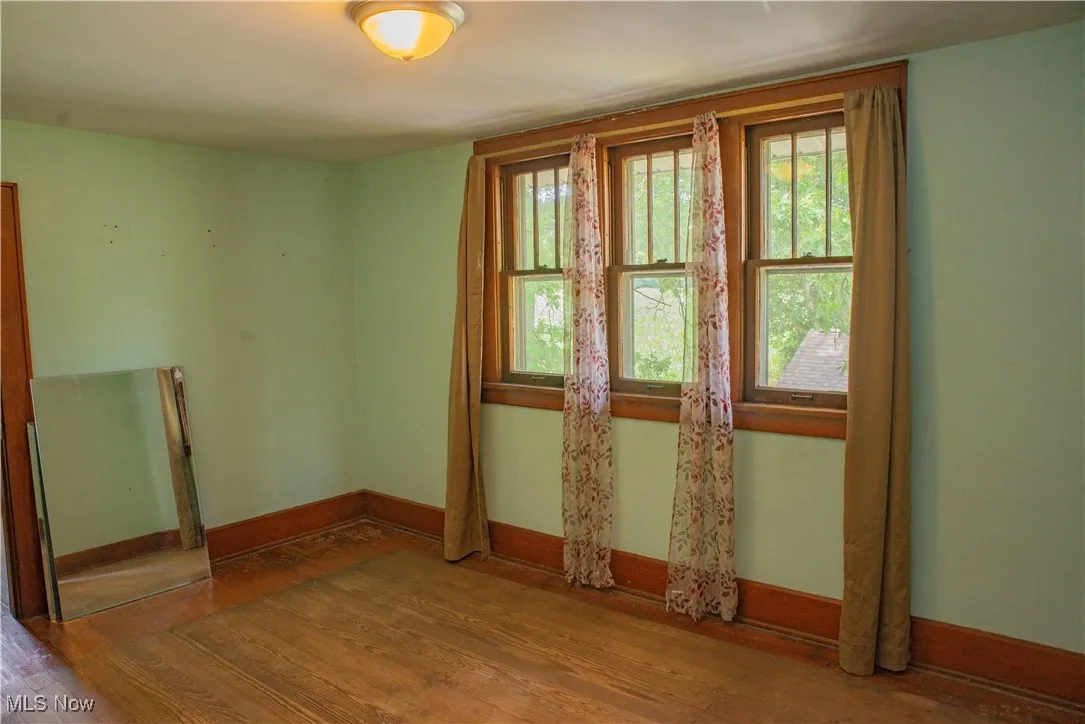 Empty room featuring wood finished floors and healthy amount of natural light