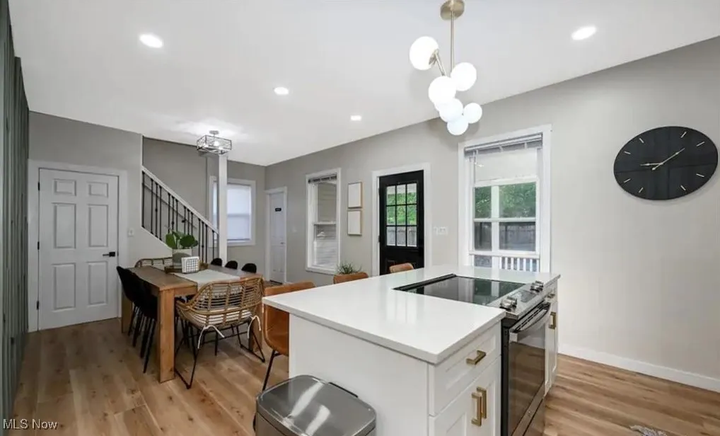 Kitchen with stainless steel range with electric cooktop, light wood finished floors, light countertops, white cabinetry, and recessed lighting