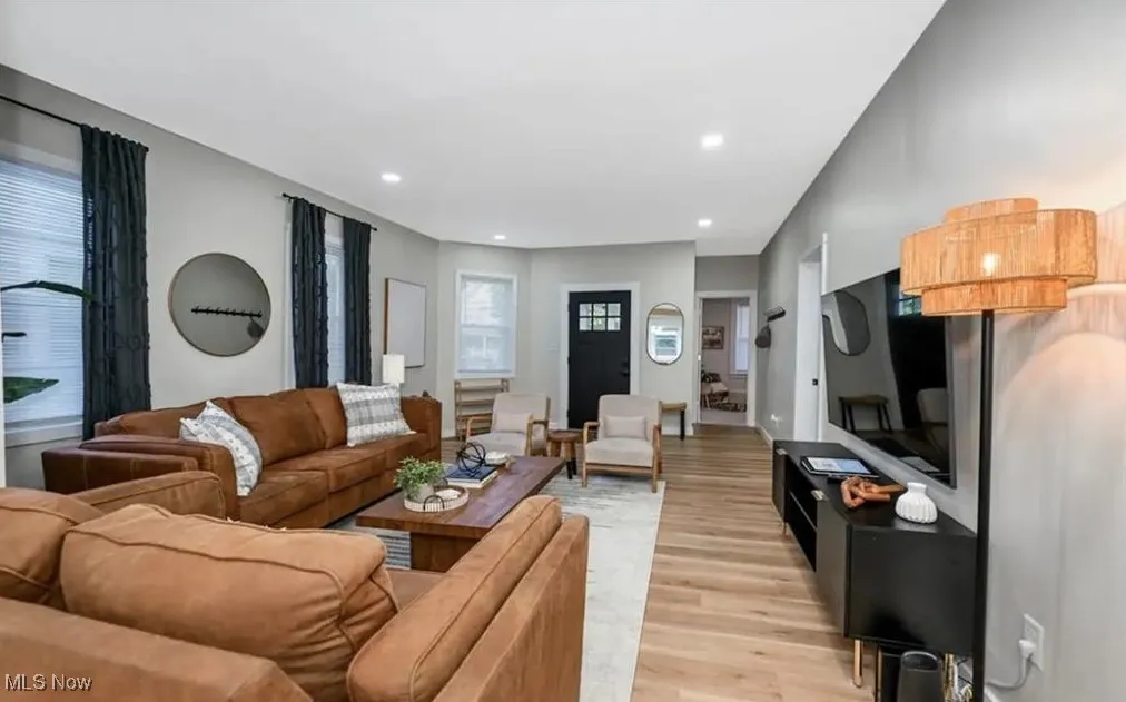 Living area with light wood finished floors and recessed lighting