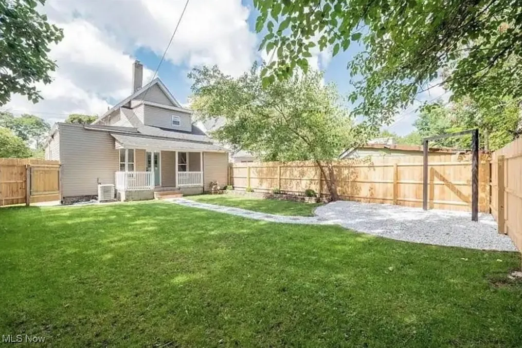 Back of property with covered porch, a chimney, and a fenced backyard
