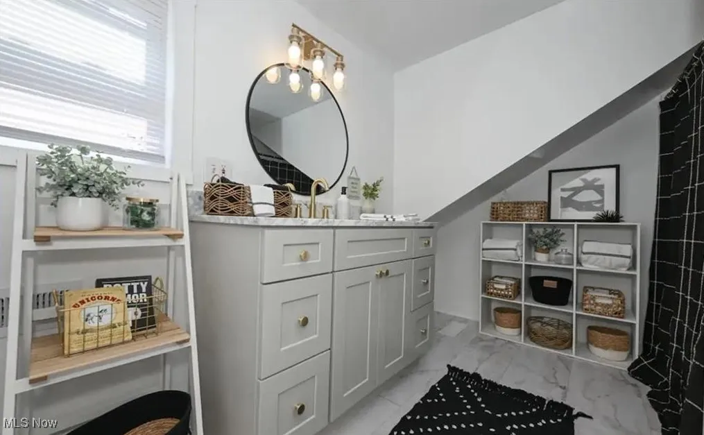 Bathroom with vanity and marble look tiles